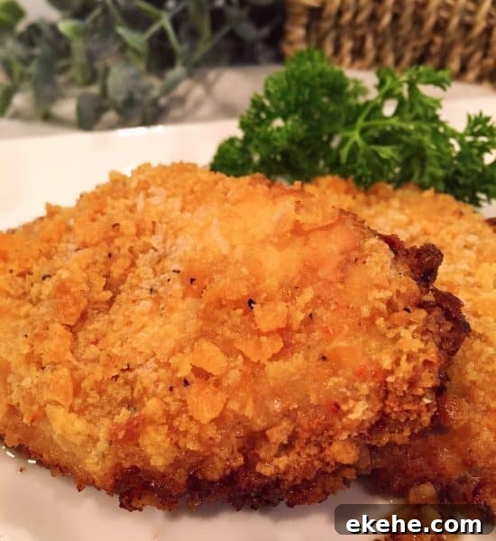 Two Oven Fried Butter Crumb Pork Chops on a white plate ready to eat!
