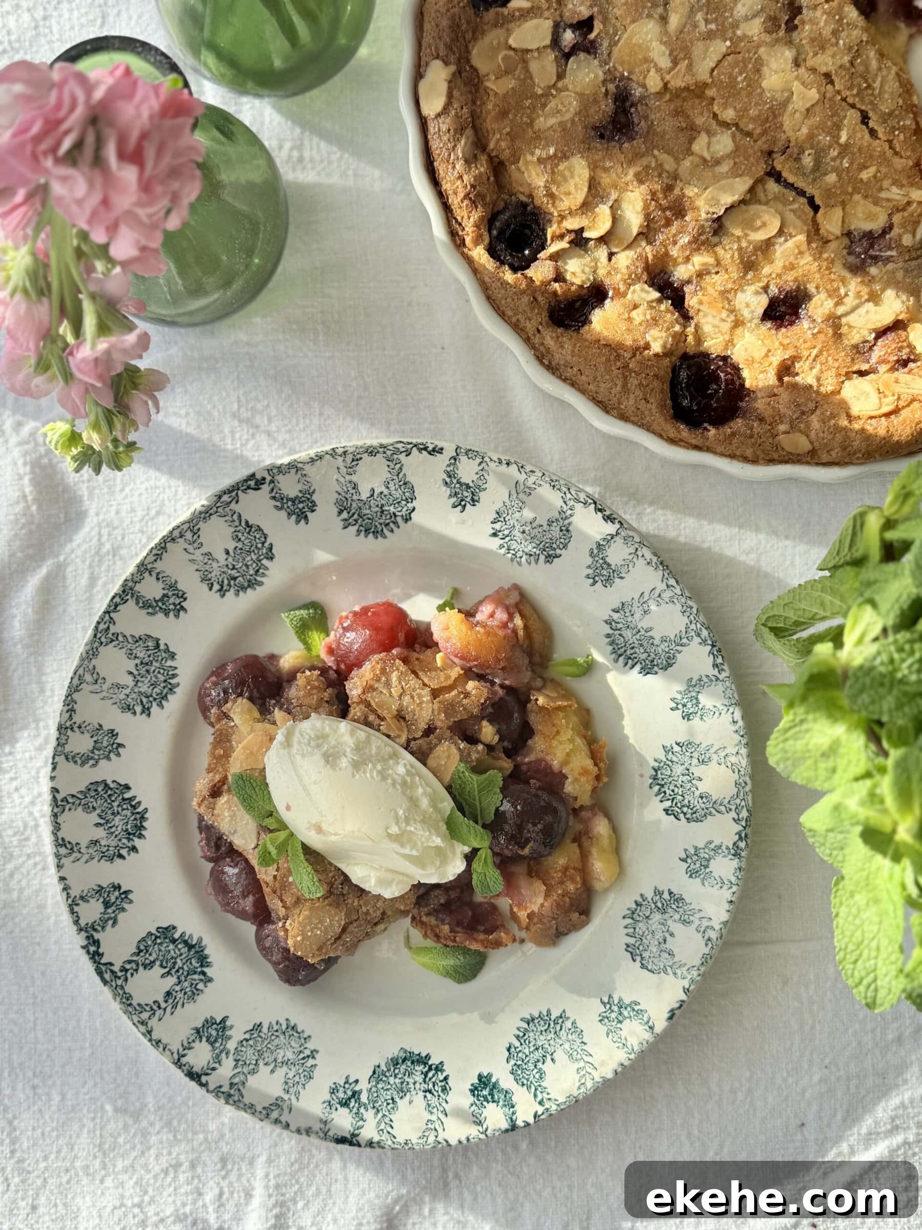 clafoutis aux cerises in a bowl with mascarpone on top and more fresh cherries.