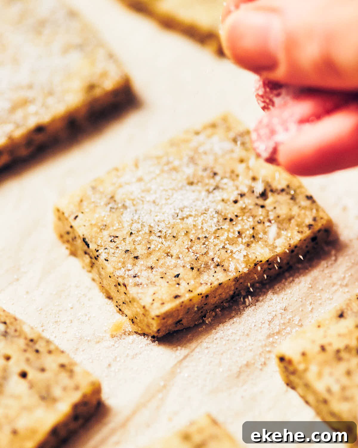Sugar being sprinkled on top of the best earl grey shortbread cookies.