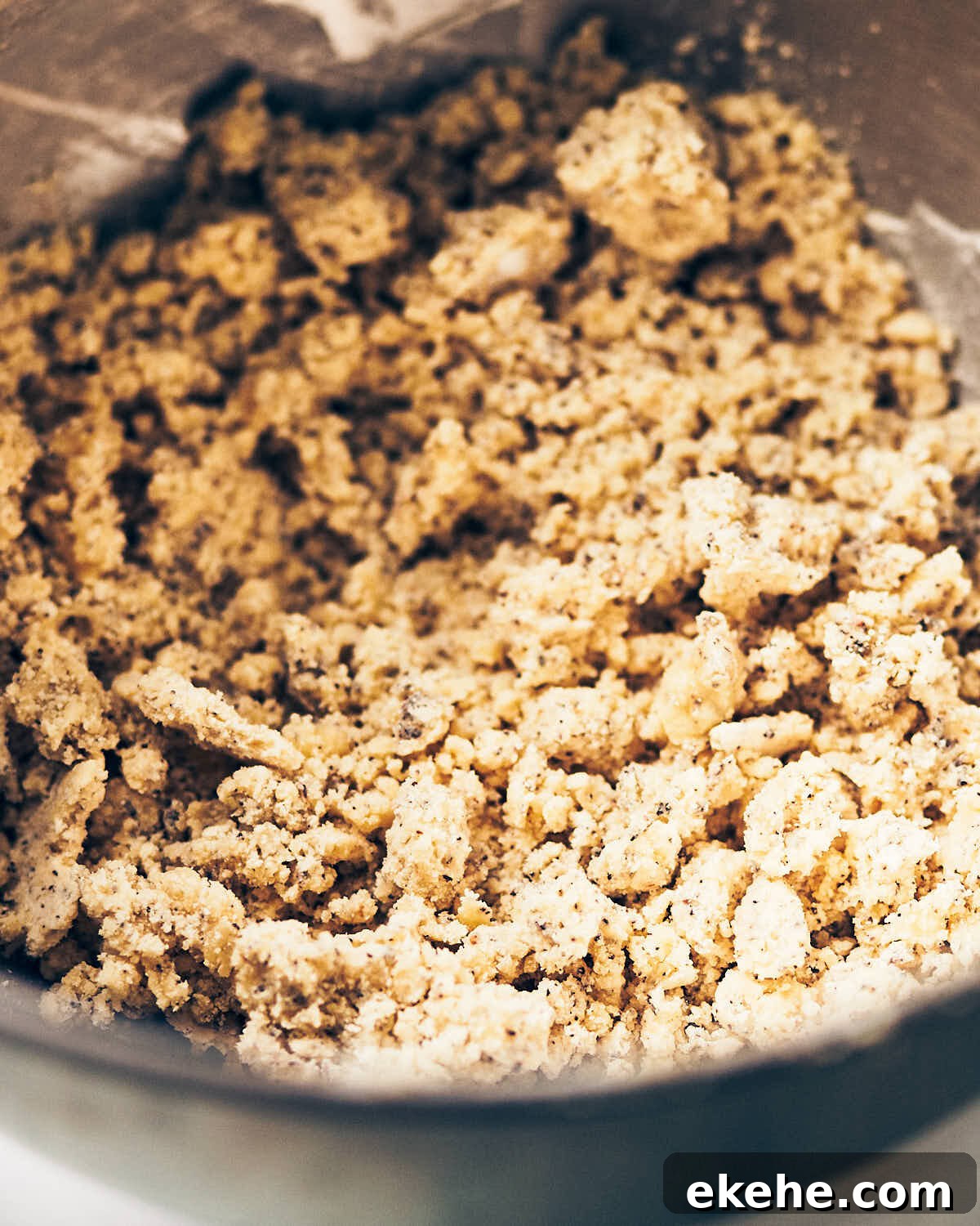 Crumbly dough for earl grey shortbread cookies in a mixing bowl.