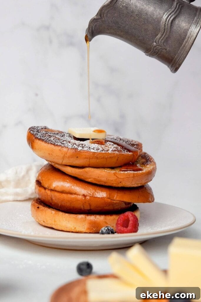 pouring syrup on top of a stack of french toast bagels