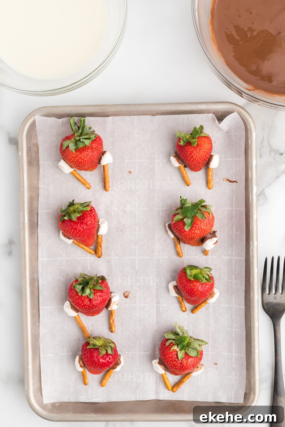 Attaching the legs to the strawberries.