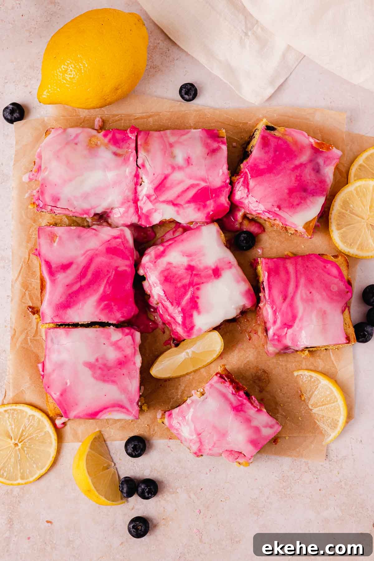 glazed blueberry brownies with swirled white and purple glaze on parchment paper