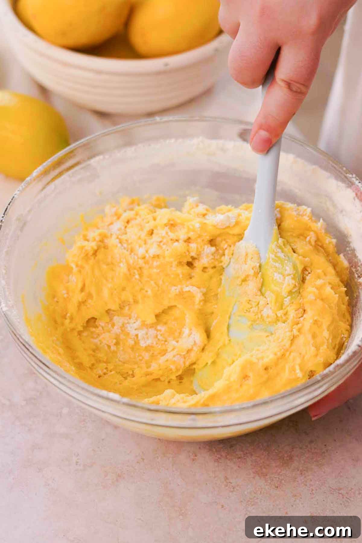 folding brownie batter with spatula in large glass bowl