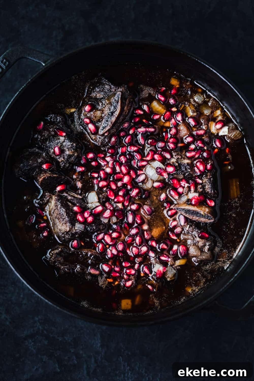 red wine braised short ribs, with pomegranate arils , overhead shot.