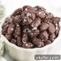 chocolate covered almonds with sea salt in a white bowl