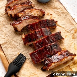 Cut oven baked ribs on a piece of parchment paper after baking in the oven.