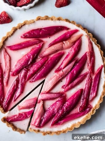Strawberry rhubarb panna cotta tart with a slice cut into it