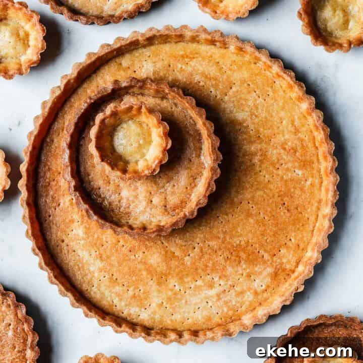 Golden brown baked tart shells in tartlet, mini and large sizes.