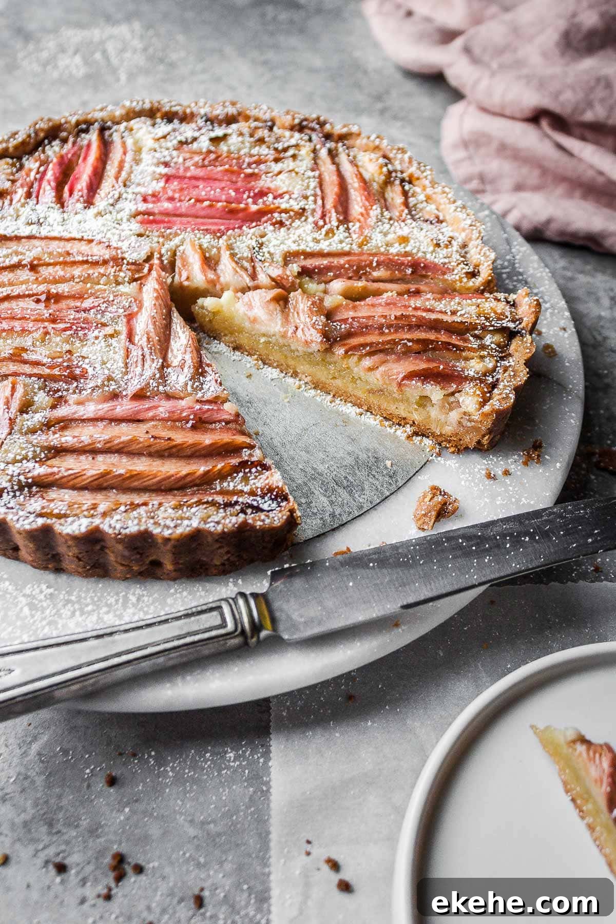 An angled view of a tart filled with almond cream and rhubarb.