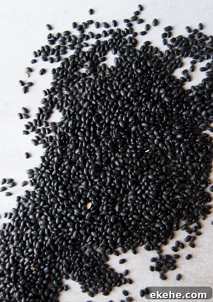 Lots of black beans scattered on a white background
