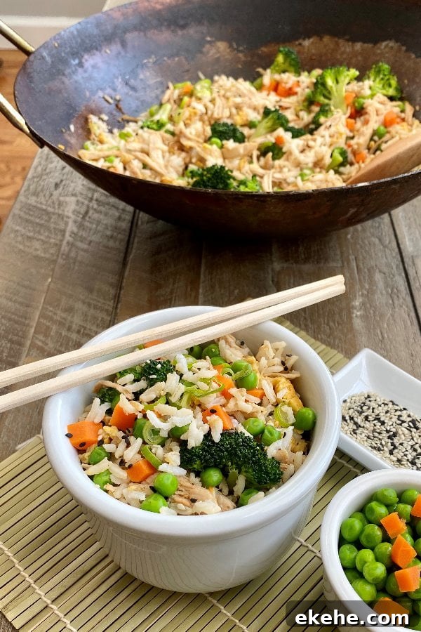 bowl of fried rice with chicken with chopsticks and a wok full of fried rice
