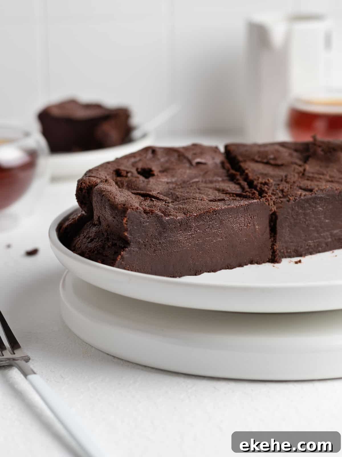 Sliced chocolate fondant cake on a white cake stand