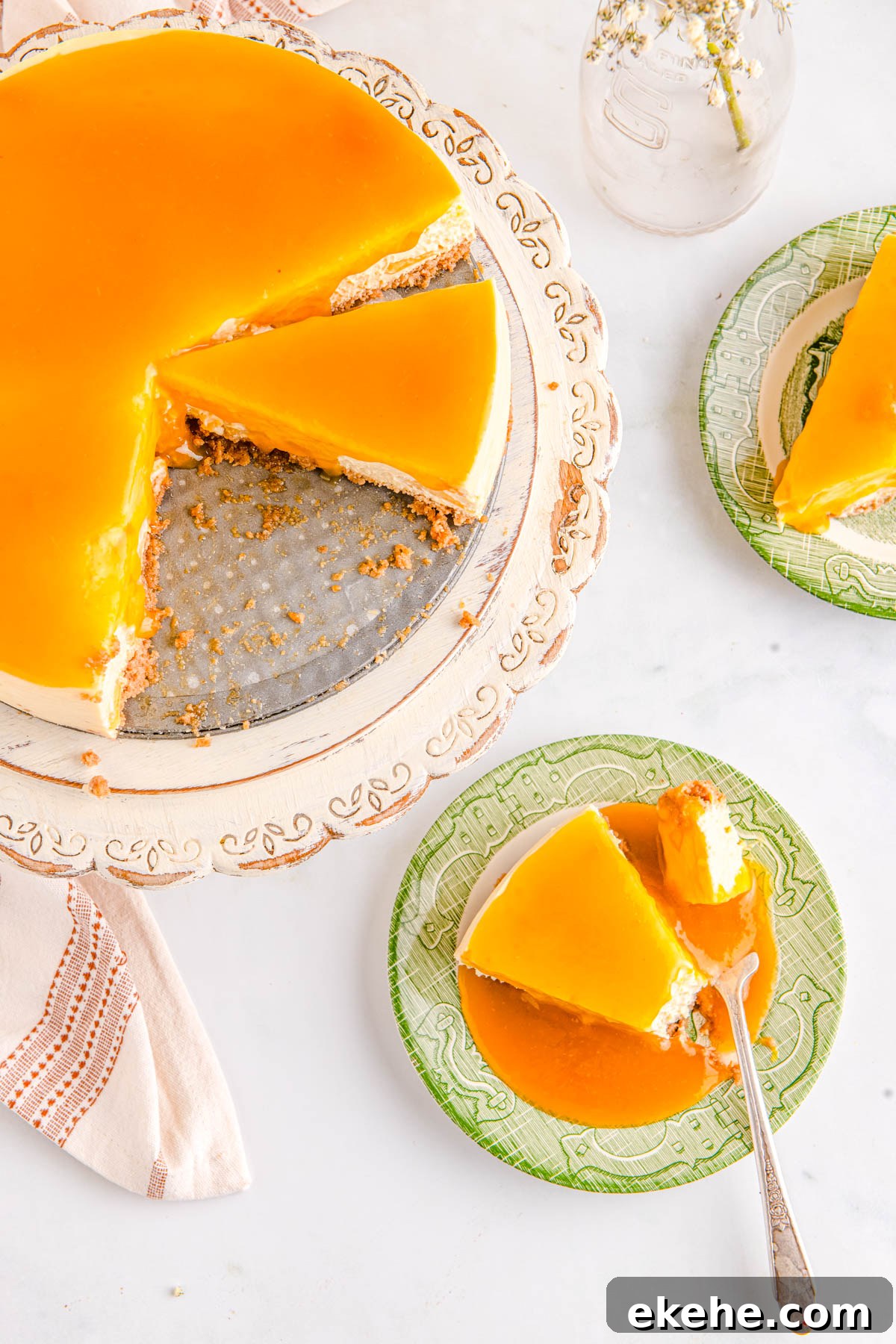 The finished cheesecake on a pedestal and slices on plates.