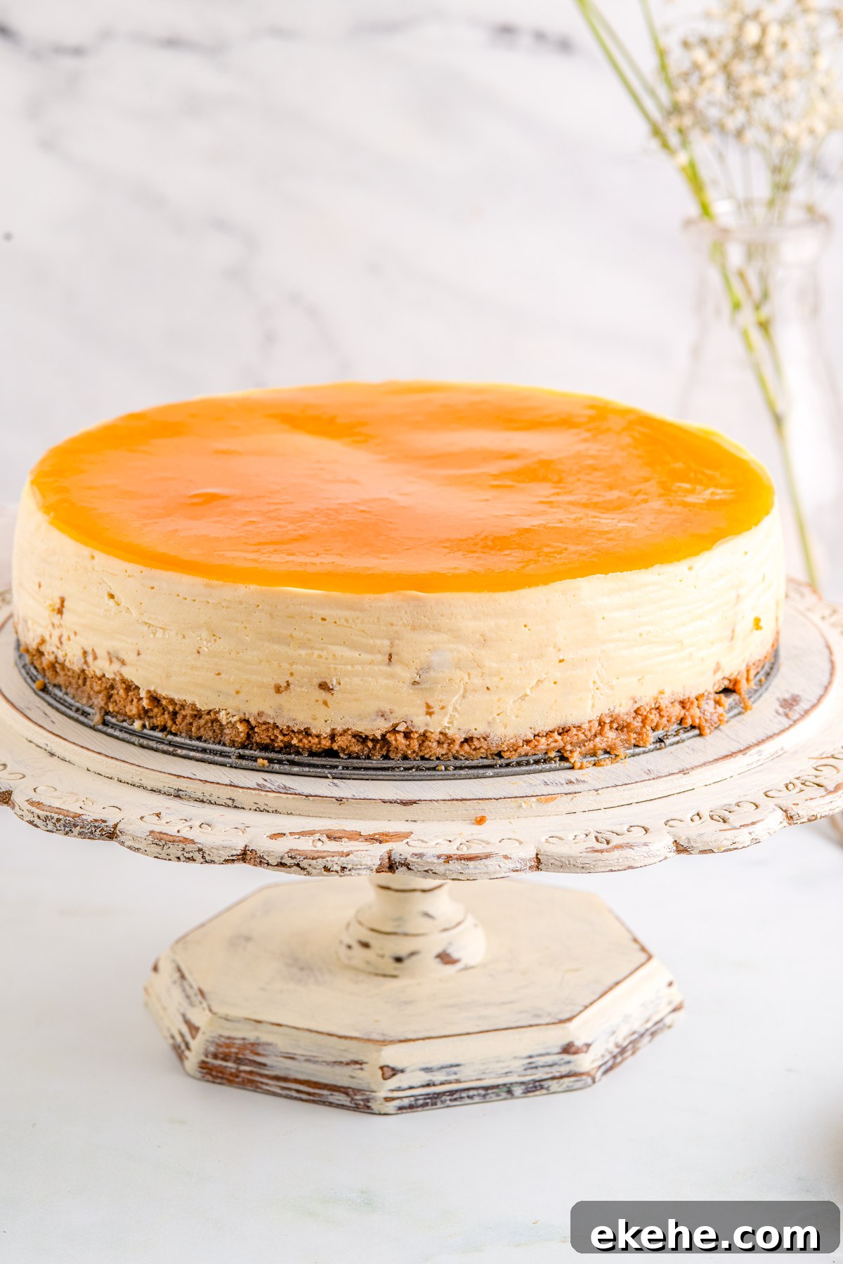The finished cheesecake on a cake pedestal.
