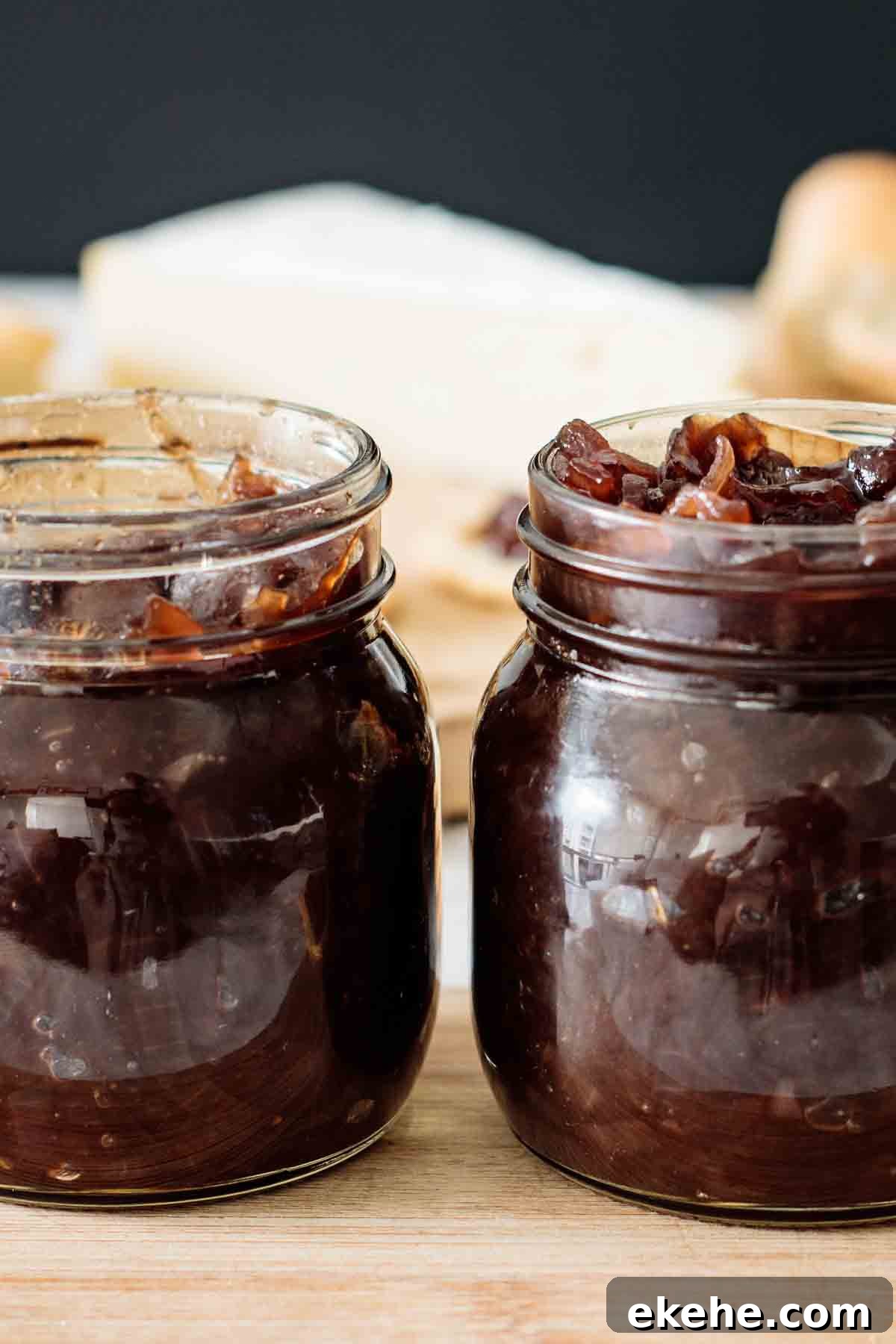 2 jars full of chutney over a wooden board.