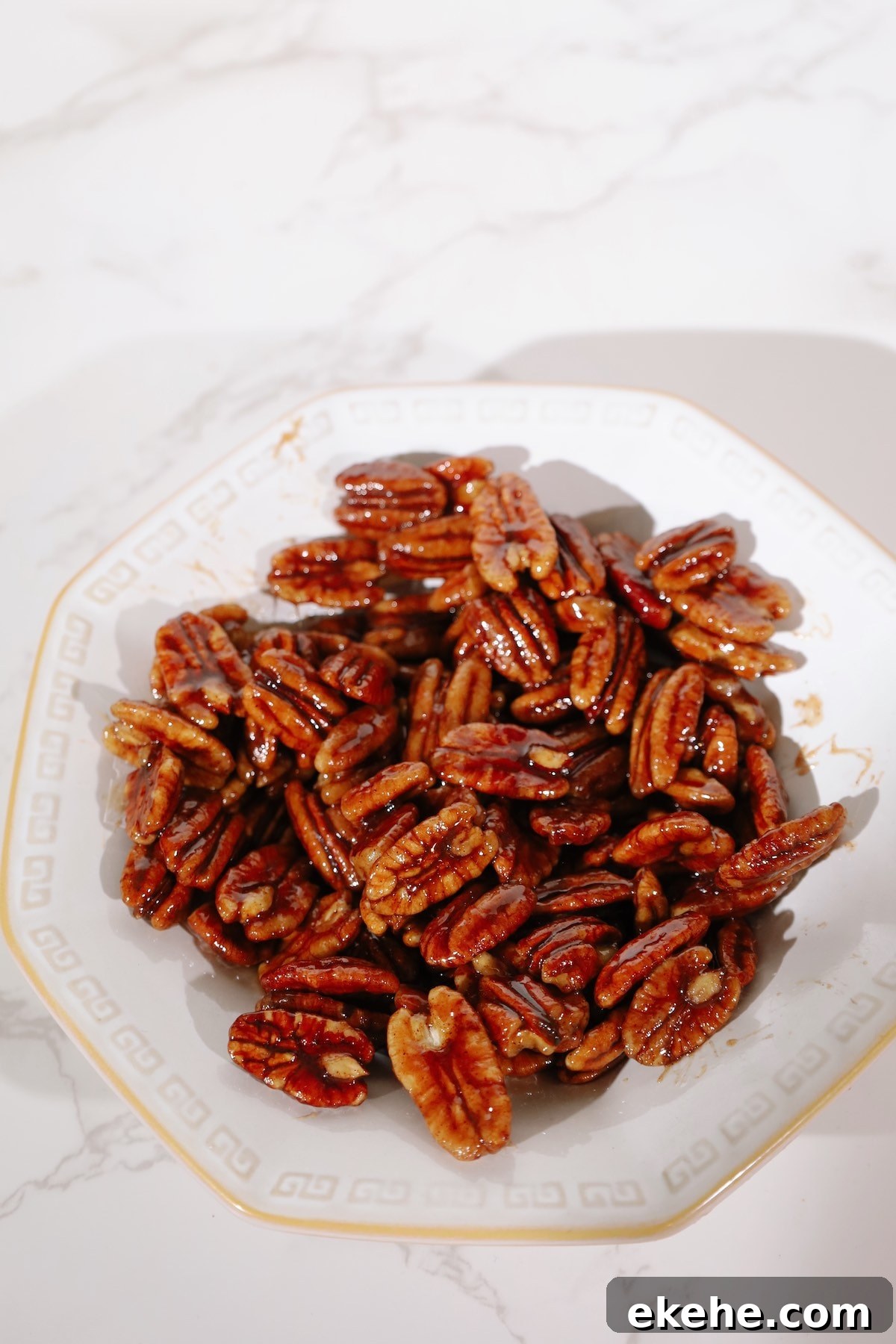 Candied pecans recipe in a white bowl.