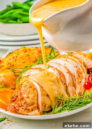 Slow Cooker Turkey Breast on a plate with gravy being poured on top.