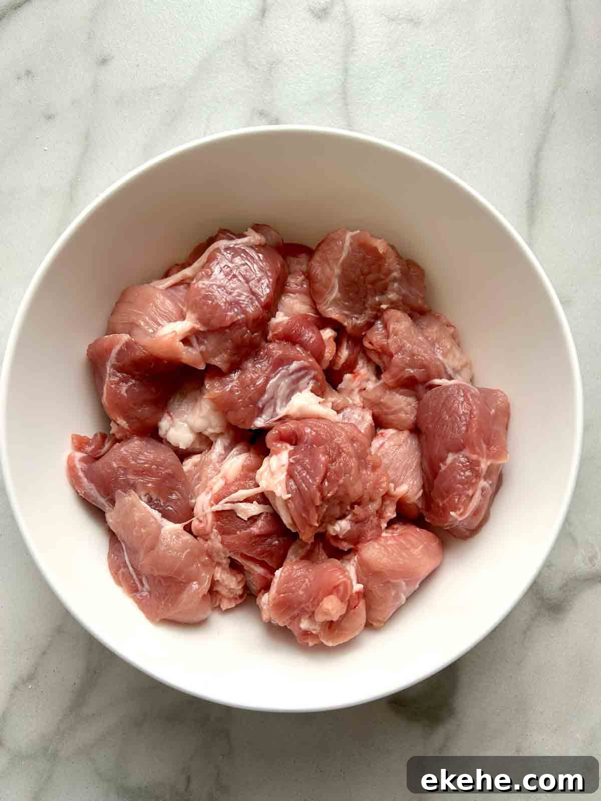 pork cut into cubes in bowl.