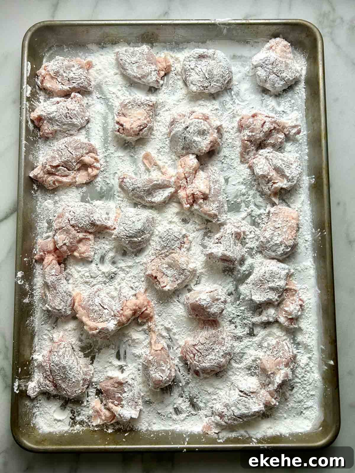 coated pork pieces resting on baking sheet.