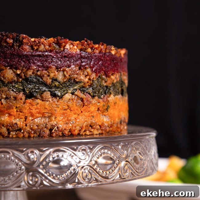 A layered nut loaf on a cake pedestal, ready to be sliced.