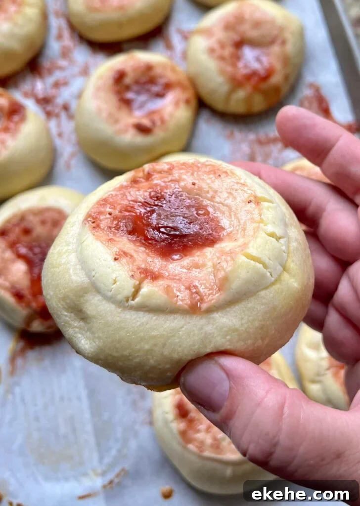 Close-up of a baked sourdough kolache with fruit jam center and cream cheese filling.