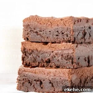 Stack of three brownies with chocolate frosting