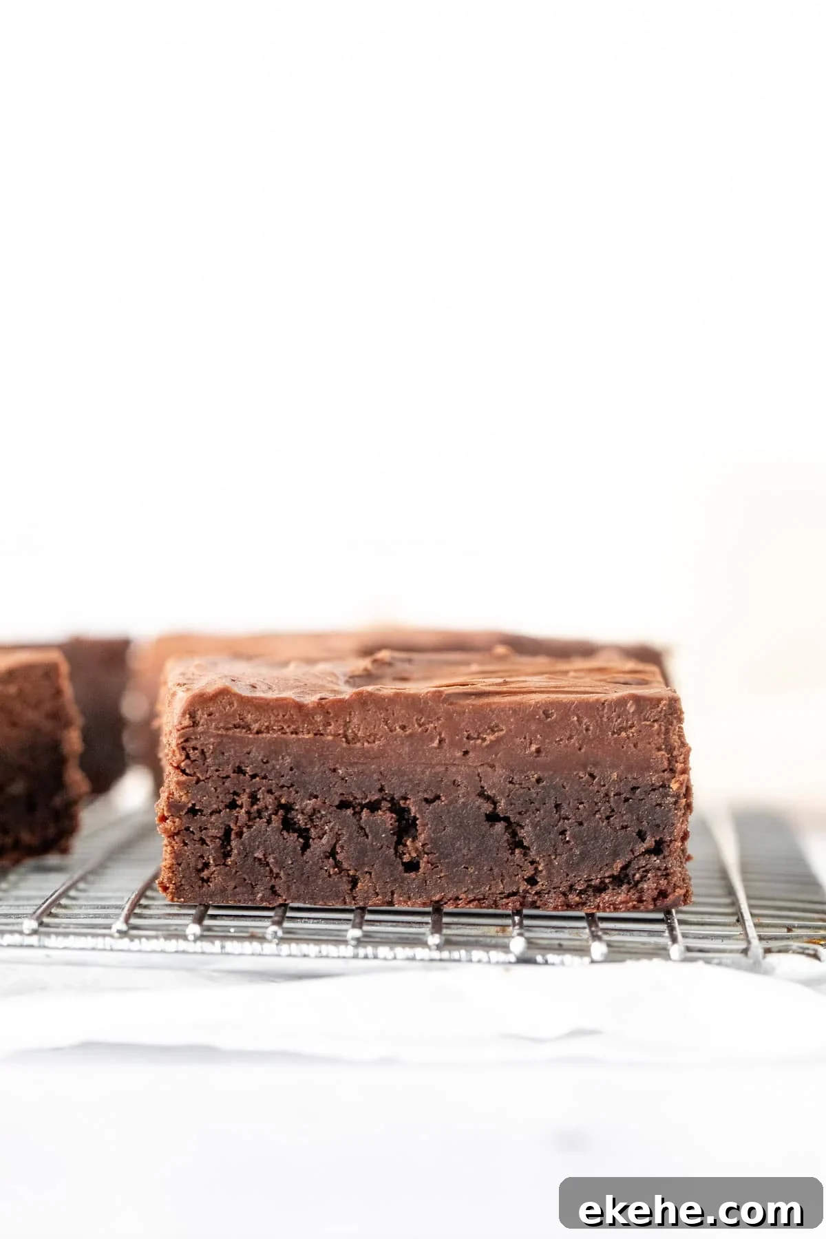Brownie on cooling rack topped with chocolate frosting