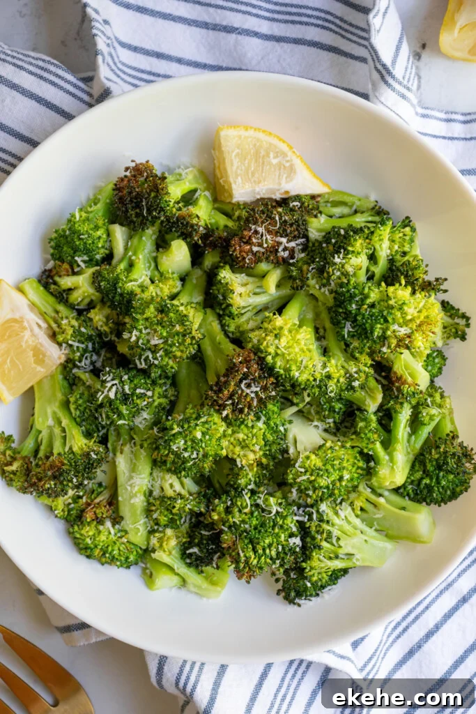Close up of air fryer broccoli in a bowl garnished with parmesan cheese.