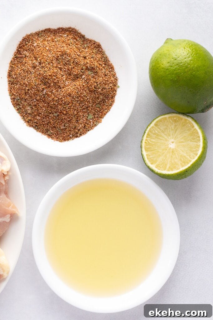Top down shot of a ingredients for taco marinade, including a white plate with oil, a white plate with spices, and one and a half limes, all on a white surface.