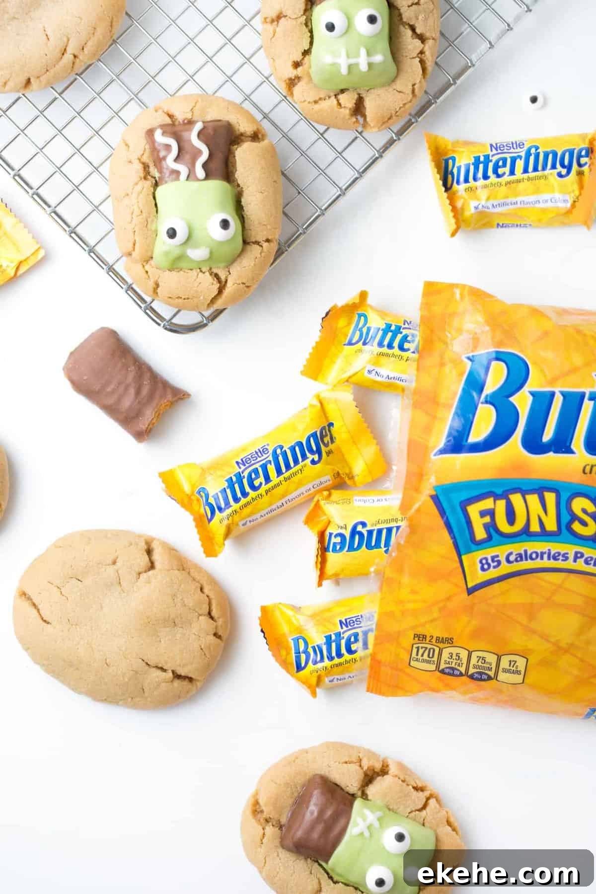 Open bag of Butterfinger fun size candy bars with peanut butter cookies on wire rack decorated to look like Frankenstein.