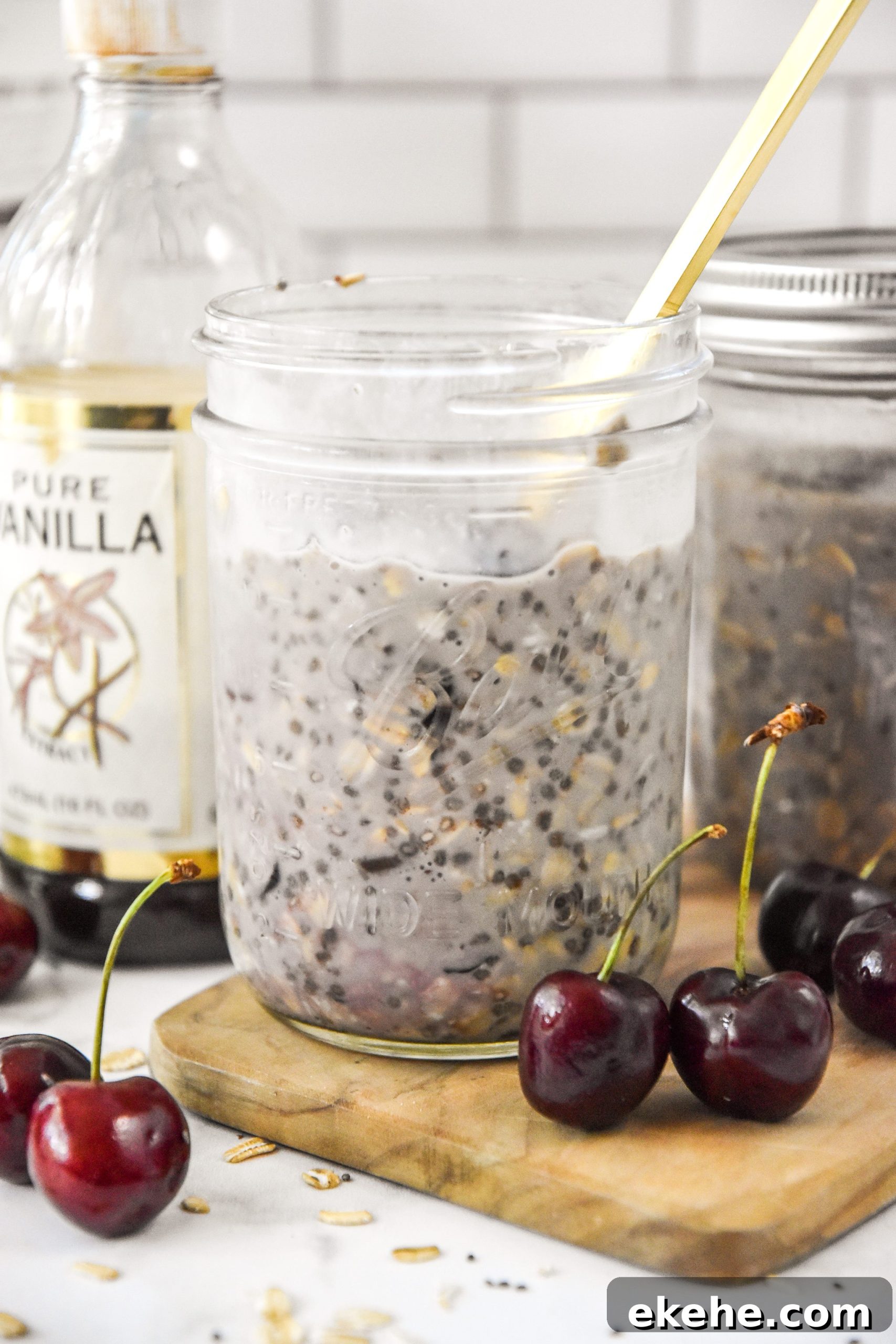 cherry vanilla overnight oats in a mason jar with cherries around.