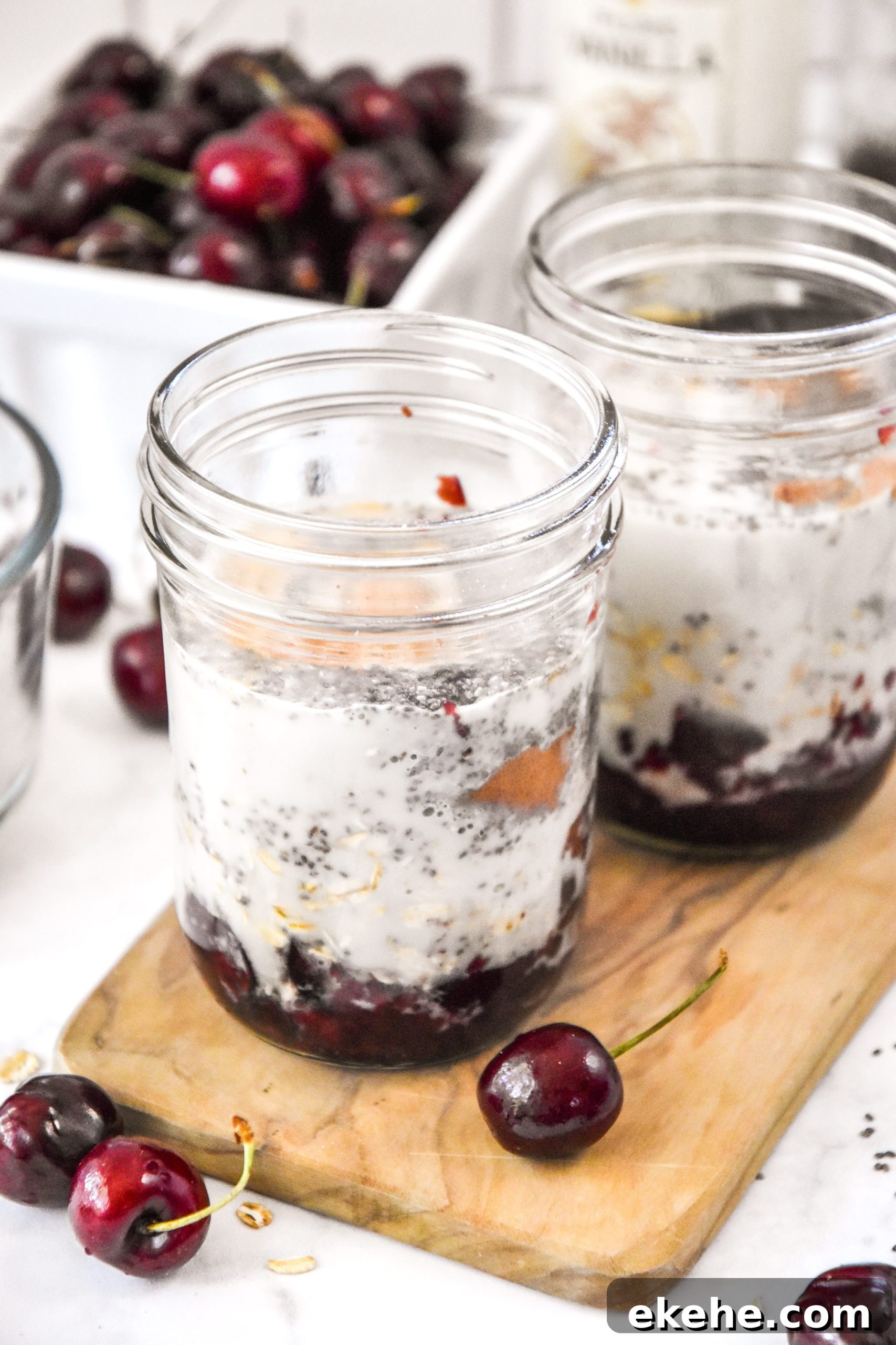 two jars of cherry vanilla overnight oats before being stirred up.