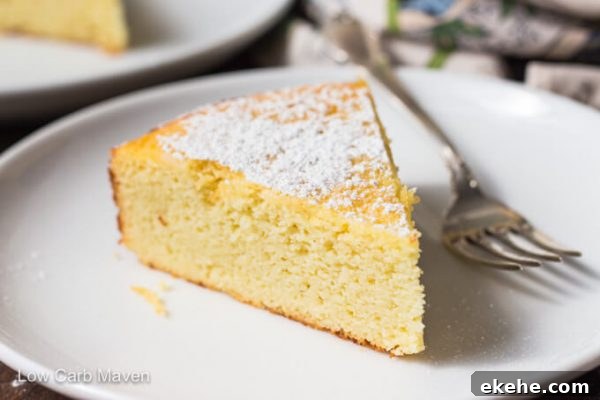 Slice of keto lemon ricotta cake with powdered sugar on a white plate with fork.