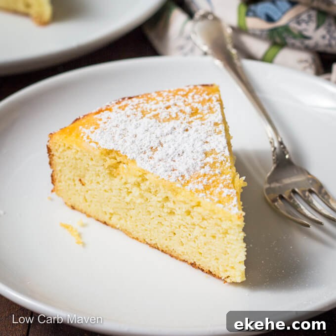 Slice of lemon ricotta cake with powdered sugar on a white plate with fork.