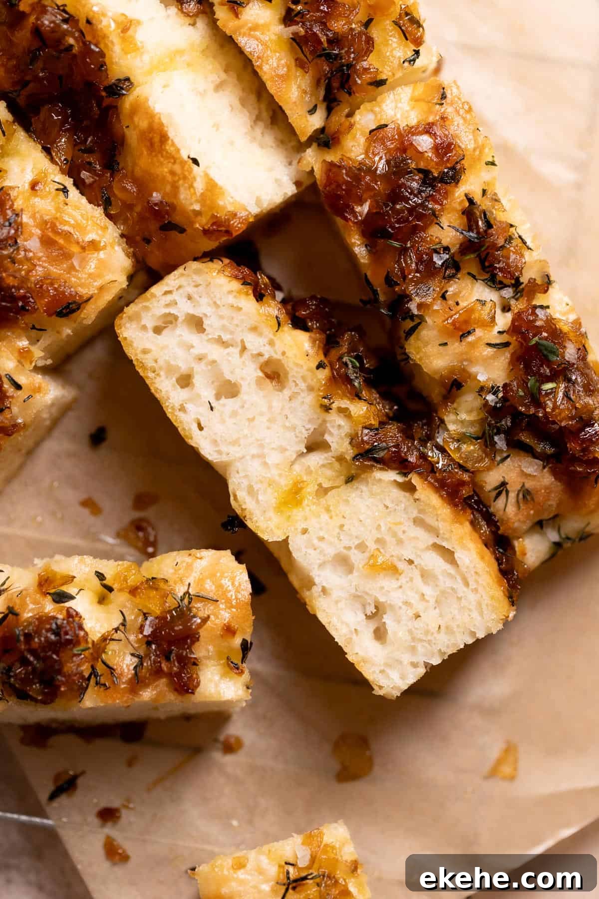 slices of focaccia with caramelized onions on parchment paper.