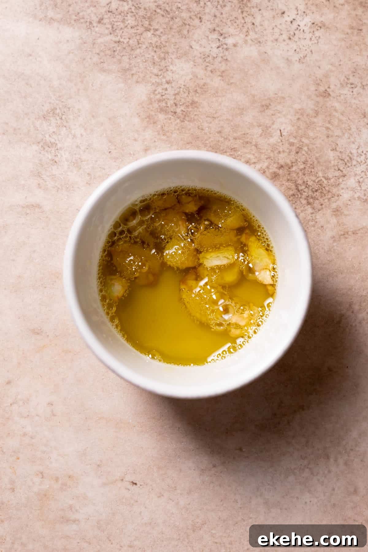 garlic cloves and olive oil in a white bowl.