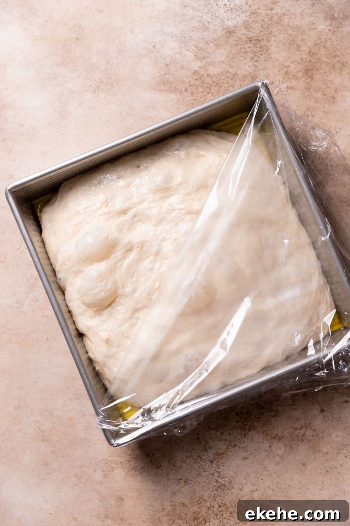 the bubbly focaccia dough in a baking pan after the second rise.