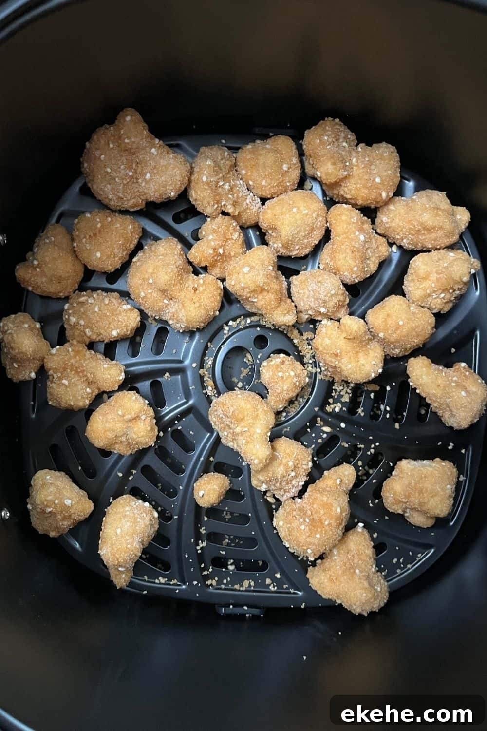 frozen cauliflower wings in the basket of an air fryer