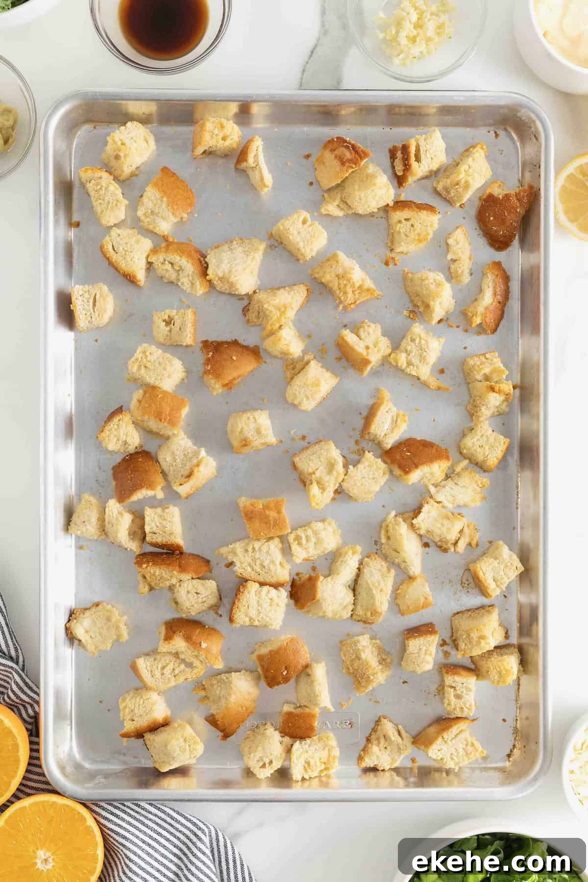 Baked croutons on an aluminum baking sheet.