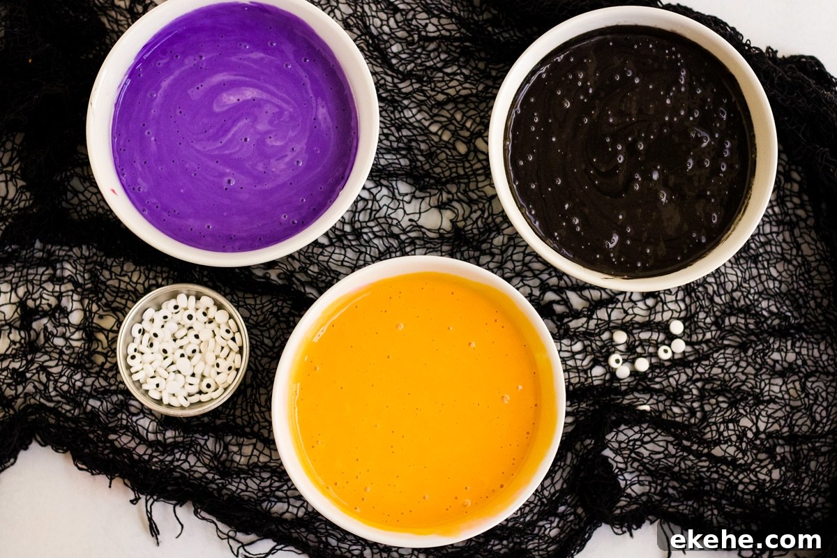 Three bowls of colored pancake batter to make Halloween Pancakes.
