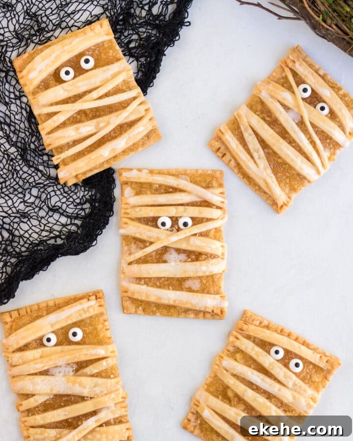 Air Fryer Mummy Apple Tarts on a white background with candy eyes.