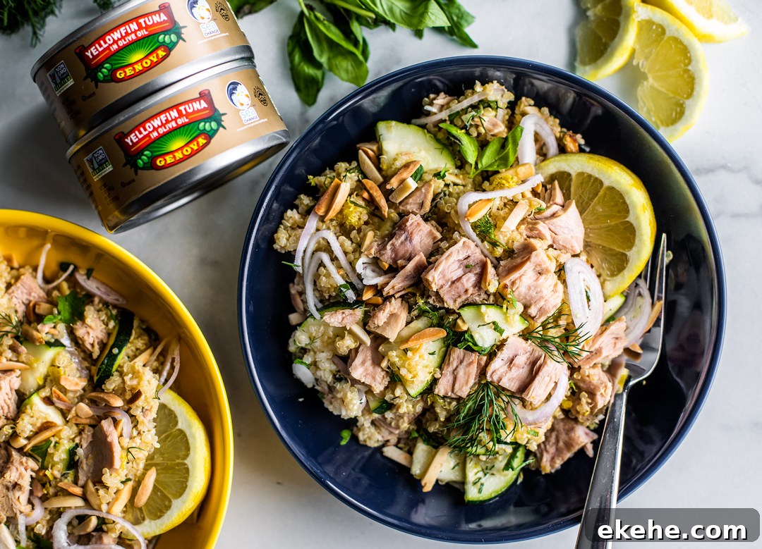 Bowls of quinoa salad with cans of Genova tuna stacked next to them.