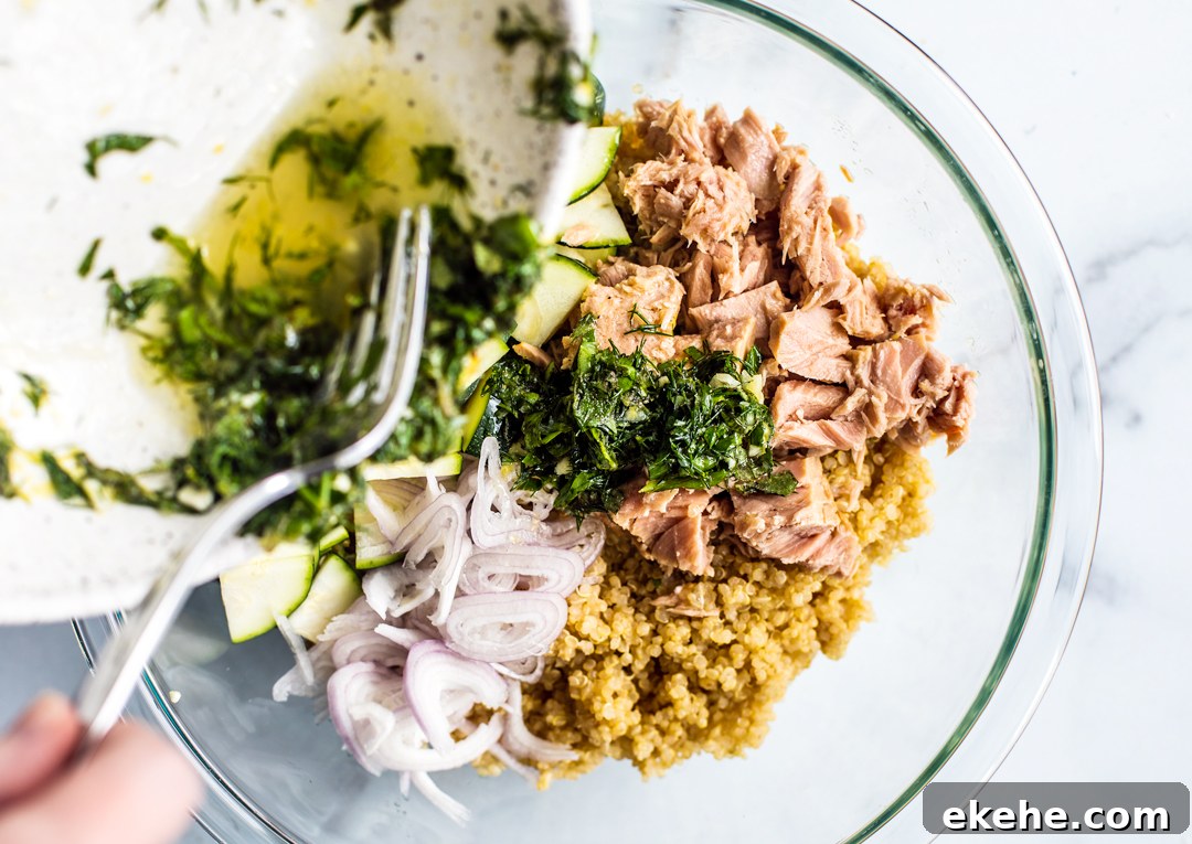 Dressing being drizzle over salad ingredients.