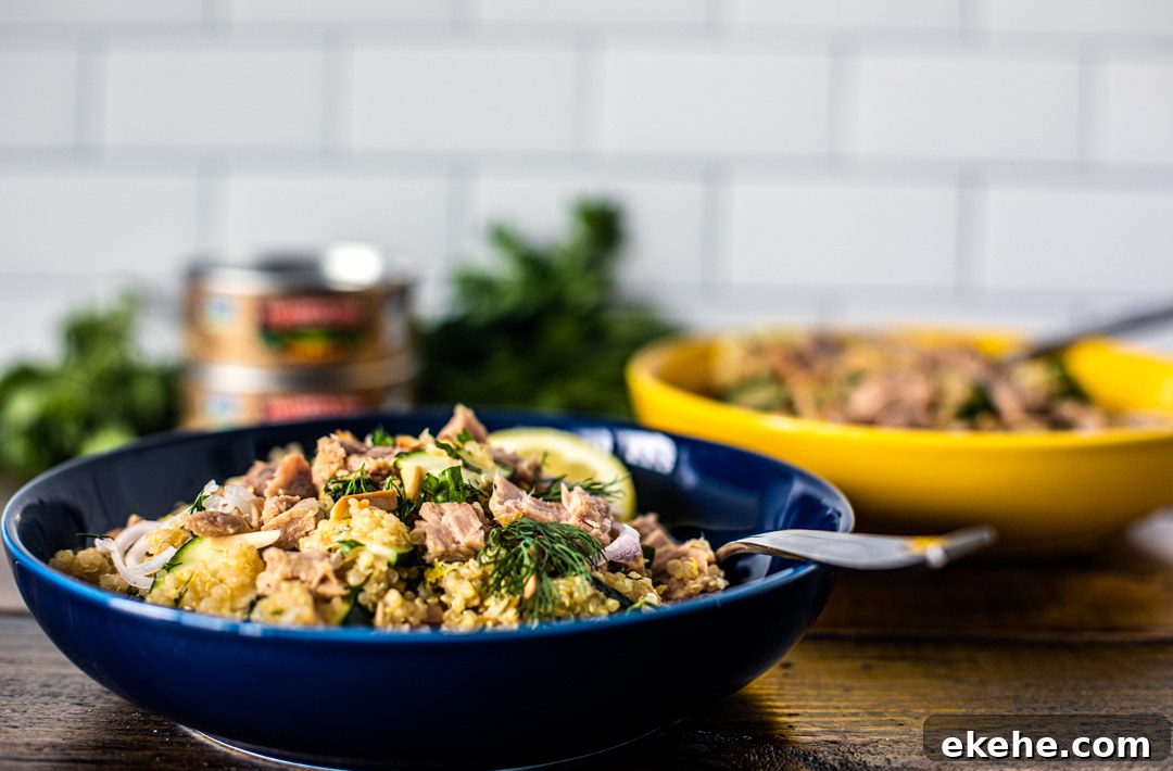 Side shot of bowls of quinoa salad topped with large flakes of tuna.