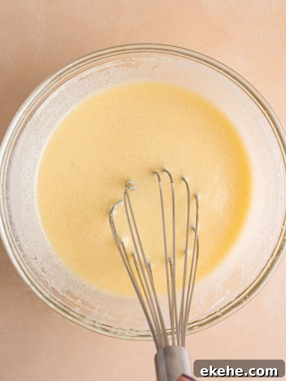 Whisking egg, kefir, oil, and vanilla extract in a bowl.