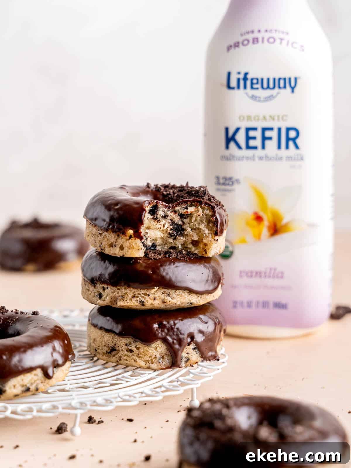 A stack of cookies and cream donuts next to a bottle of Lifeway Vanilla Whole Milk Kefir.