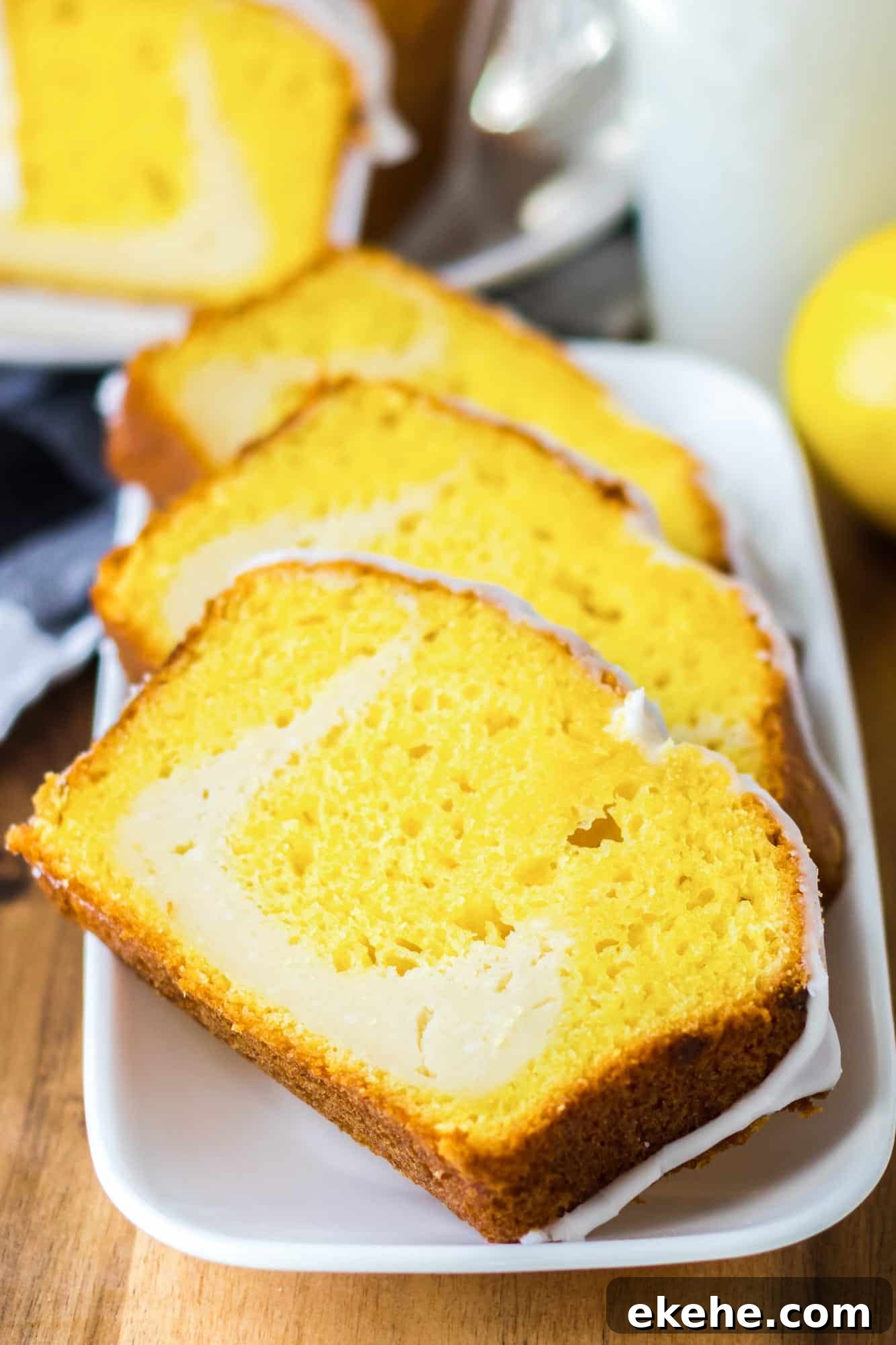 Slices of lemon cheesecake loaf on a white rectangular plate