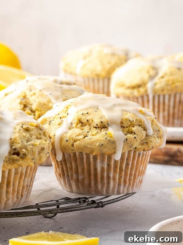 Lemon poppy seed muffins with lemon icing on a cooling rack.