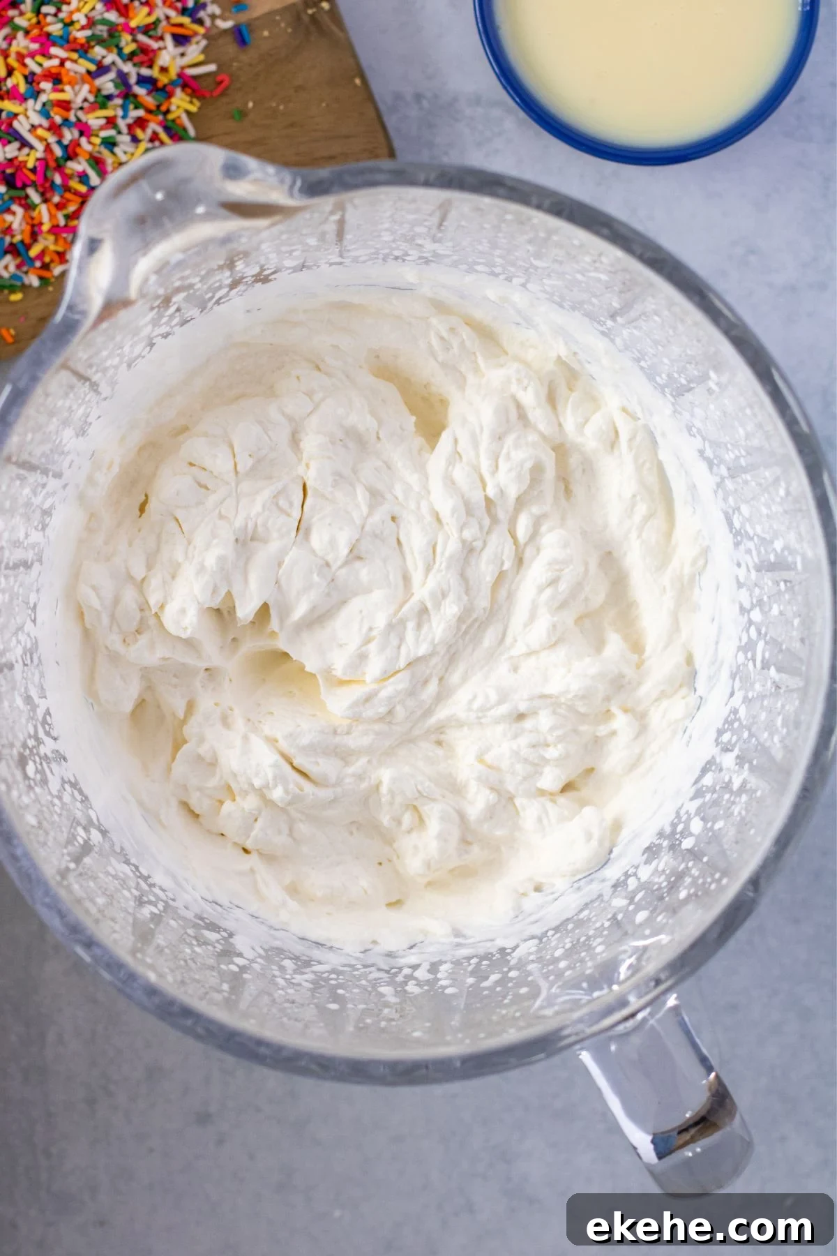 Heavy cream and vanilla beat together in a mixing bowl into stiff peaks.